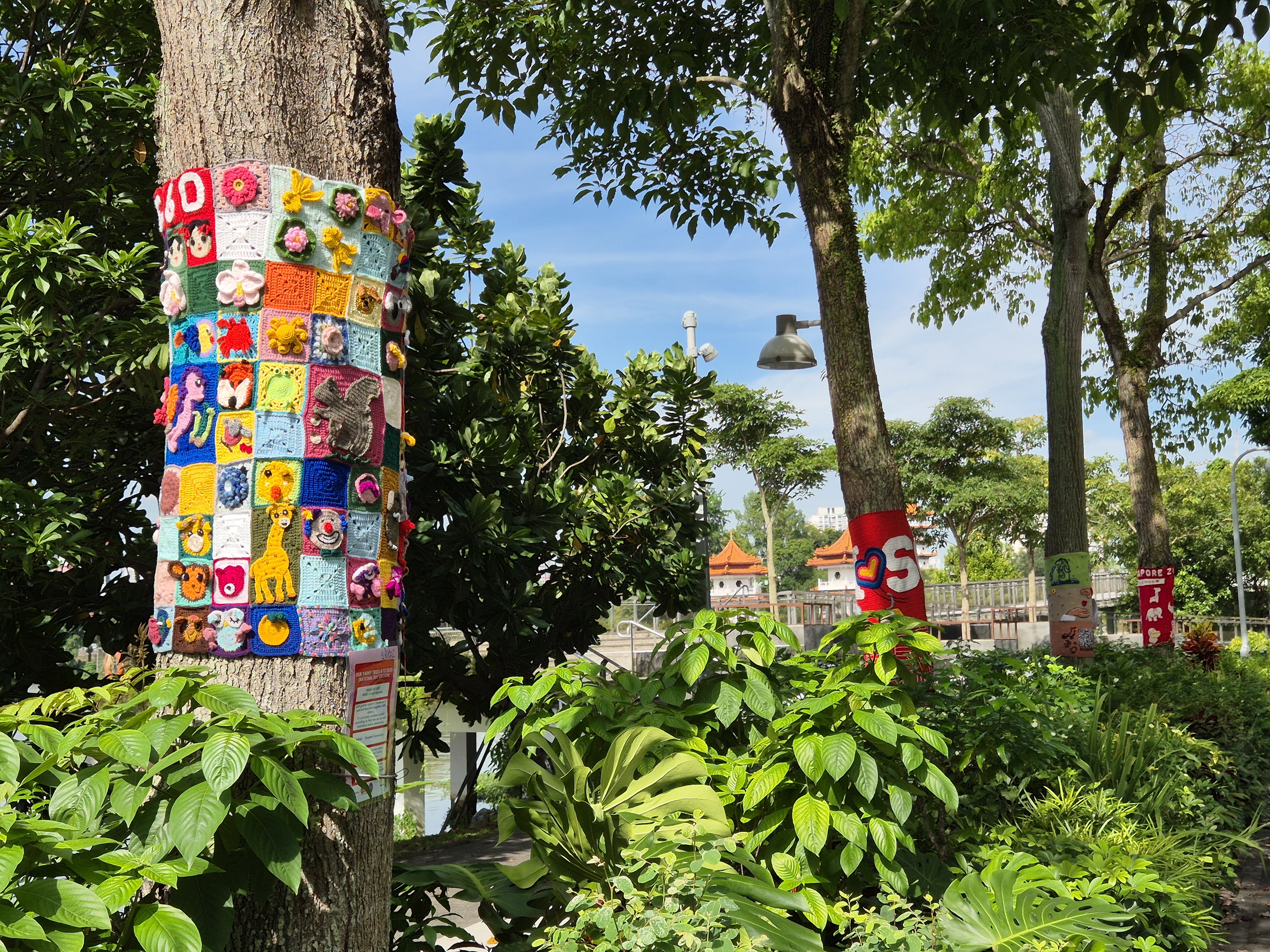 Tree trunks wrapped in colourful crocheted panels at Jurong Lake Gardens.